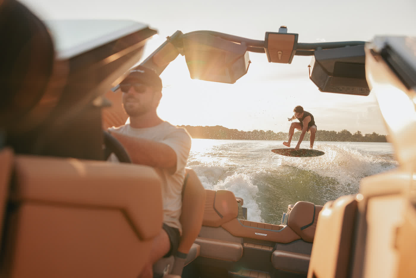 Blick vom Wakeboat auf den Wakesurfer bei Sonnenuntergang